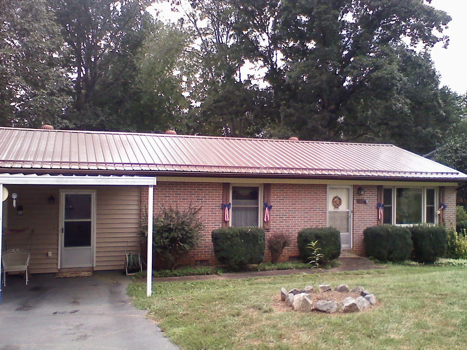Bronze metal roof and carport on a brick ranch home — Roof Repair work by our crew in Cortland